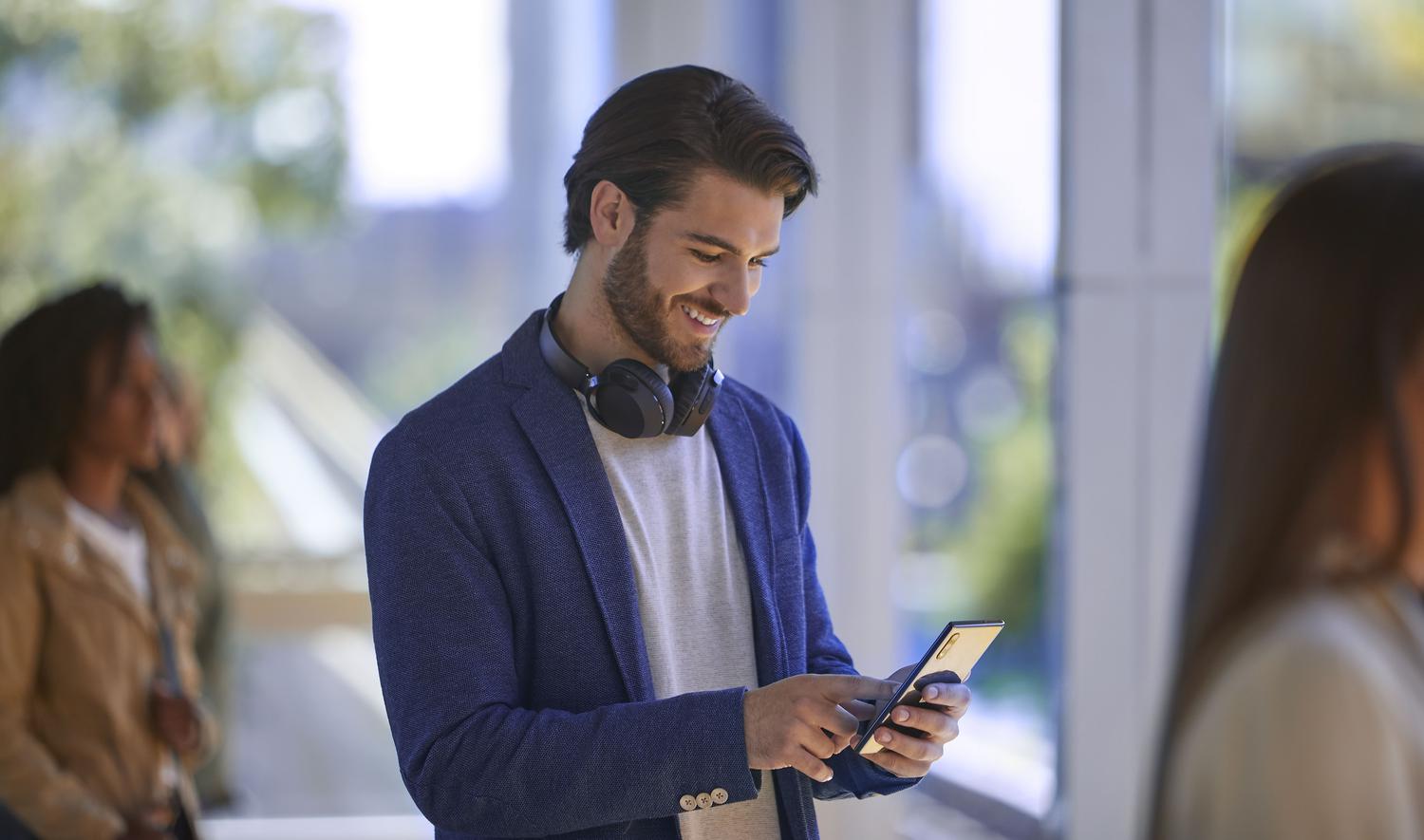 A man smiling at his phone